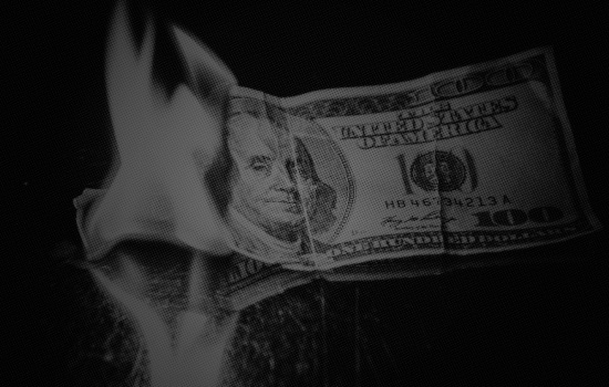 One hundred dollar bill burning thanks to spending and taxation
